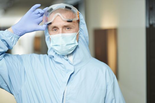 Male employee carrying out disinfection in special protective clothing and wearing glasses. Coronavirus and quarantine concept