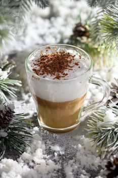 Christmas latte macchiato. A great hot coffee drink with chocolate shavings, among the snow-covered pine branches and snow.