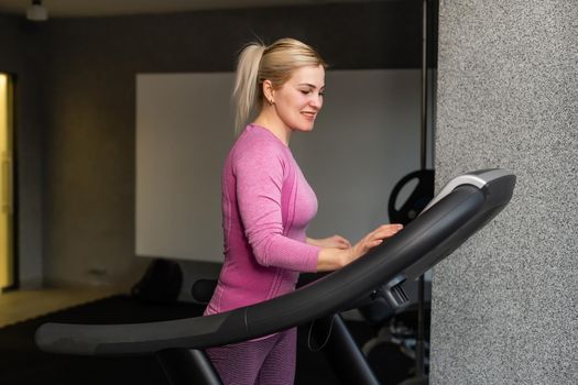 young fitness woman execute exercise with exercise-machine in gym, horizontal photo