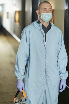 Medical staff wearing protective clothing while walking along corridor in hotel. Coronavirus and quarantine concept