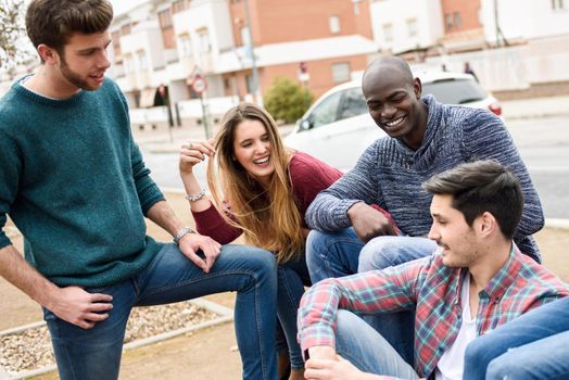 Group of multi-ethnic young people having fun together outdoors in urban background