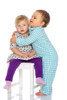 Toddler boy and girl, cute hugging in studio on a white background. The concept of a harmonious development of a child in the family, a happy childhood. Isolated.