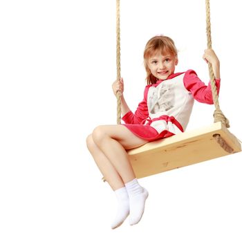 Adorable little girl swinging on a swing. She is happy to have fun and show how she can do it. The concept of summer recreation and harmonious development of the child. Isolated on white background.