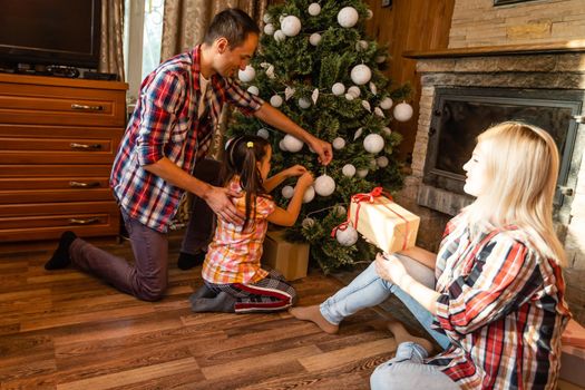 family and christmas tree in an old wooden house