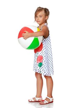 A nice little girl is playing with a big inflatable ball. The concept of a happy childhood, family recreation in nature, fitness and exercise. Isolated on white background.