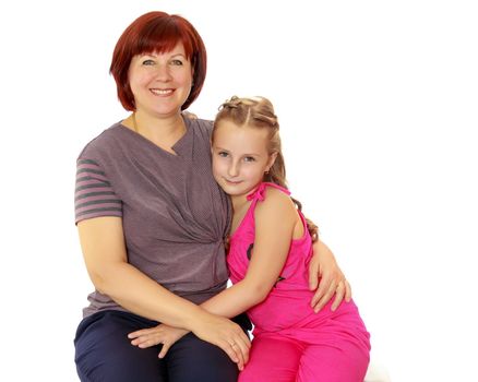 Happy family of two people,an adult mother, her beloved daughter 7 years cute cuddling on the couch.Isolated on white background.