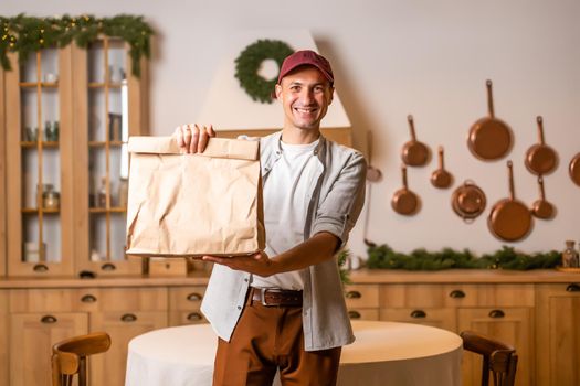 Young delivery man holding and carrying a cardbox. Buy food online in quarantine concept.