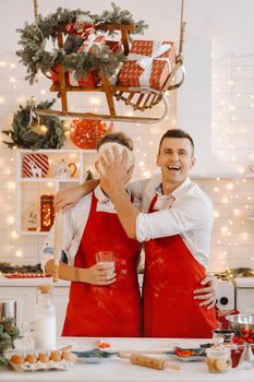 Father and son in the Christmas kitchen prepare dough for making cookies.