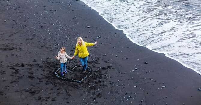 Family holiday on Tenerife, Spain, Europe. Mother and daughter outdoors on ocean. Portrait travel tourists - mom with child. Positive human emotions, active lifestyles. Happy young family on sea beach