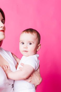 The pretty baby in white clothes on the mother's hands