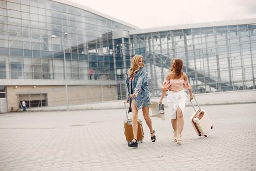 Girls at the airport. Friends with suitcasess