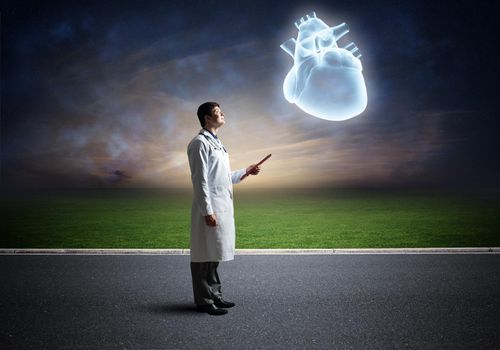 The doctor looks at the virtual projection of the heart. virtual technology in medicine