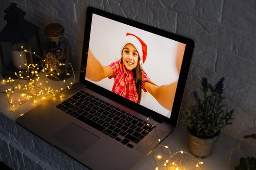 Image of open laptop family and christmas on wooden table in front of christmas tree background.