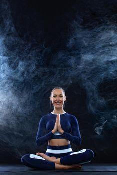 Portrait of a beautiful young woman sitting in yoga pose
