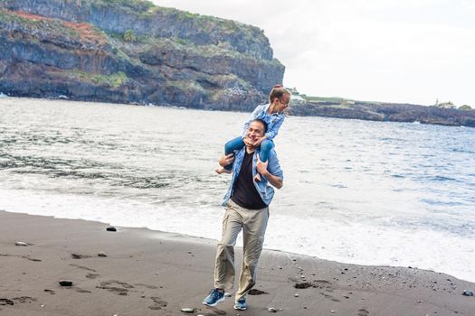 Happy family standing on the beach on the dawn time