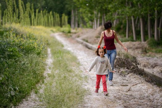 Happy mother with her little daughter in poppy field