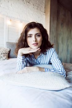 young pretty brunette woman in her bedroom sitting at window, happy smiling lifestyle people concept close up