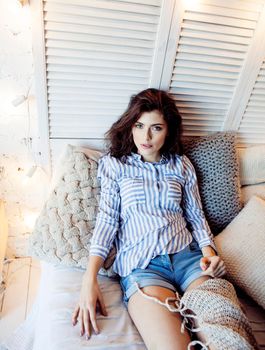 young pretty brunette woman in her bedroom sitting at window, happy smiling lifestyle people concept close up