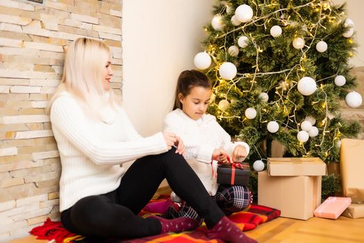 Christmas, happy family mother with daughter with gifts on Xmas Eve
