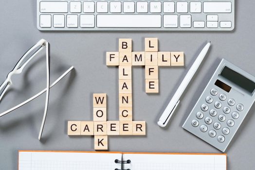 Business motivation concept with words from cubes. Still life of office workplace with crossword. Flat lay grey surface with computer keyboard and calculator. Strategy planning and business analytics.