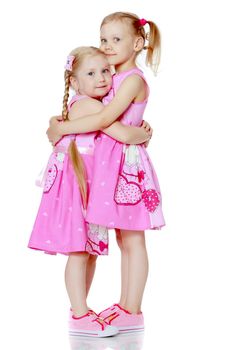 Two cute little girls in full growth, in the studio on a white background. The concept of a happy childhood, Beauty and fashion. Isolated.