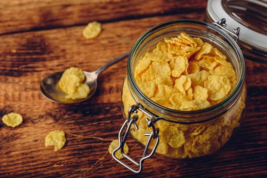 Jar of corn flakes for breakfast on wooden surface