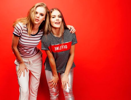 two best friends teenage girls together having fun, posing emotional on red background, besties happy smiling, lifestyle people concept close up