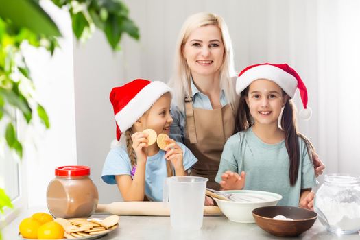 happy funny mother and children bake christmas cookies