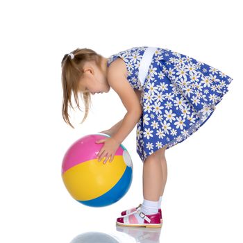 A nice little girl is playing with a big inflatable ball. The concept of a happy childhood, family recreation in nature, fitness and exercise. Isolated on white background.