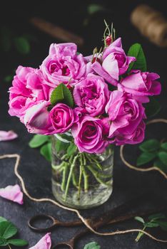 Bouquet of small pink garden roses in jar with water