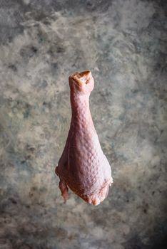 Raw turkey leg on concrete background