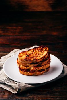 French toasts on white plate over wooden surface