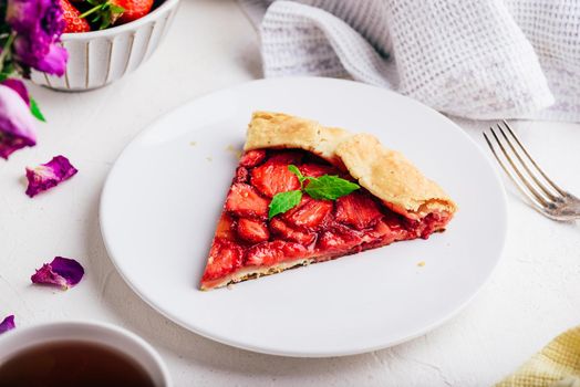 Slice Of Vegetarian Fresh Baked Strawberry Galette With Mint Leaves On White Plate