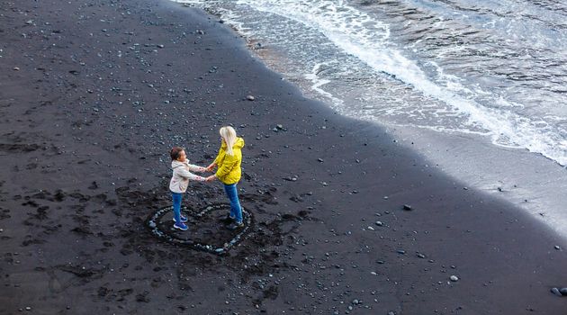 Family holiday on Tenerife, Spain, Europe. Mother and daughter outdoors on ocean. Portrait travel tourists - mom with child. Positive human emotions, active lifestyles. Happy young family on sea beach