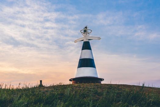 Beacon with the pointer on the hill in sunset light