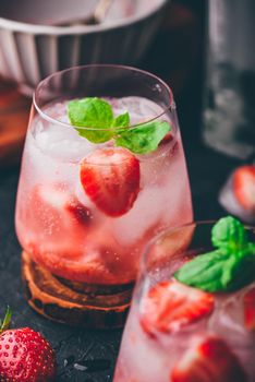 Two glasses of cocktail with fresh and frozen strawberry, gin and tonic