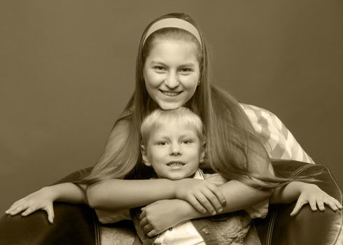 A teenage girl with her younger brother. studio photo session. The concept of family happiness.