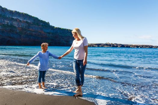 Family holiday on Tenerife, Spain. Mother with children outdoors on ocean. Portrait travel tourists - mom with kids. Positive human emotions, active lifestyles. Happy young family on sea beach