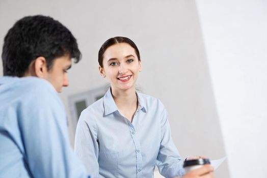 portrait of a young attractive woman discussing documents with a colleague. teamwork conceppt