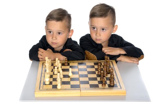 Two brothers are playing chess at home. Game, education, lifestyle concept.Isolated on white background