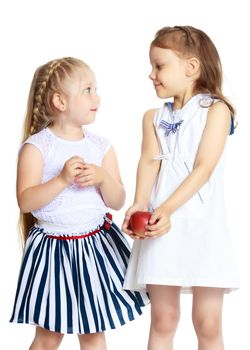 Two cute little girls with apples, in the studio on a white background. Concept of happy childhood, healthy eating. Isolated.