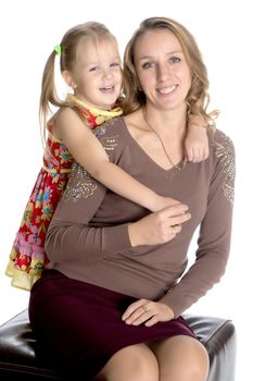 Young mother and little daughter gently embrace. The concept of Happy Childhood, Family Happiness, Raising a Child. Isolated on white background.