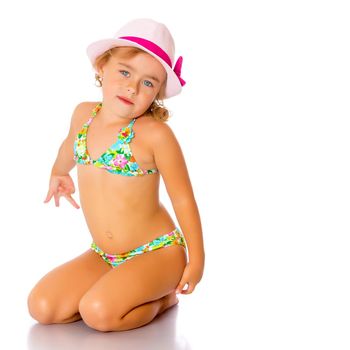 Beautiful little tanned girl in a swimsuit and a hat. The concept of summer family vacations, rest on the sea, beautiful tan. Isolated on white background.