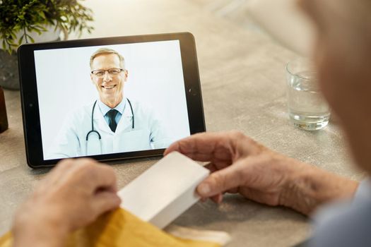 Outgoing medical worker smiling from tablet screen on a video call while his patient holding a pack of pills