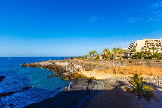 Tropical island of Tenerife. The coast of a Spanish city on the Atlantic ocean. Panorama of the city and beach on the island of Tenerife. Background color with gradient and grain, sound effect.