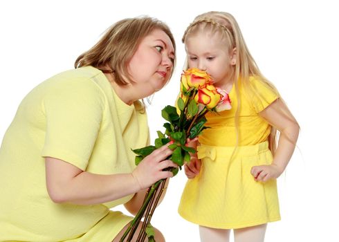 Mom and little daughter plus the size of the model, with a bouquet of flowers. A woman and a daughter smile in a happy manner. Good for the concept of health, happiness, diet, obesity, weight loss.