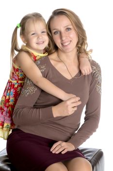 Young mother and little daughter gently embrace. The concept of Happy Childhood, Family Happiness, Raising a Child. Isolated on white background.