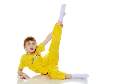 Girl with a short bangs on her head and bright yellow overalls.She crouched down on the white advertising banner.