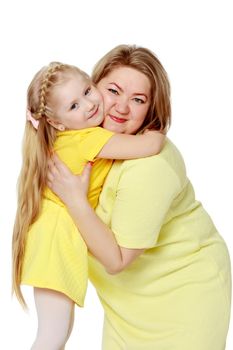 Mom and little daughter plus the size of the model, gently embrace. A woman and her daughter are smiling in a happy manner. Good for the concept of health, happiness, diet, obesity, weight loss.