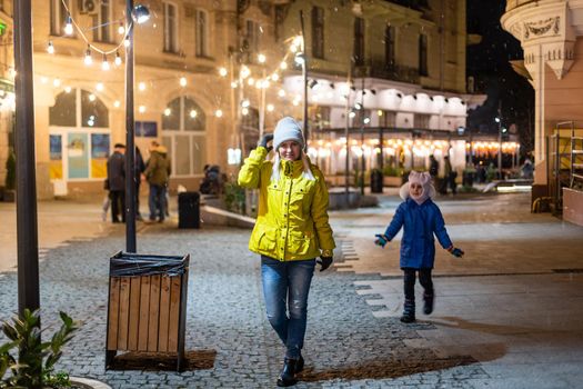 Lviv, Ukraine old town rynok market square alley in Lvov with winter Christmas illumination at night with snow.